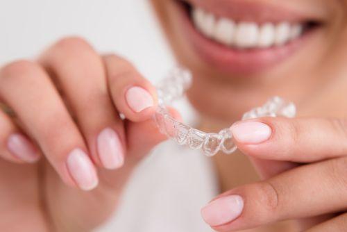 patient holding clear aligners in mccrae