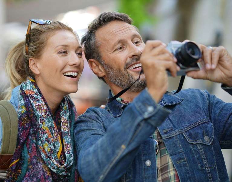 couple with porcelain veneers in mccrae looking at photos taken with camera